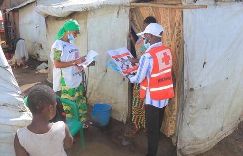 DRC Red Cross volunteers sharing Ebola prevention information with a community member